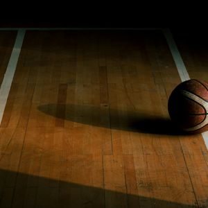 Candle light and sports equipment on a wooden floor