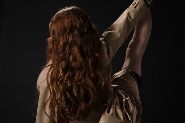 Woman performing gentle stretches in a sunlit modern studio